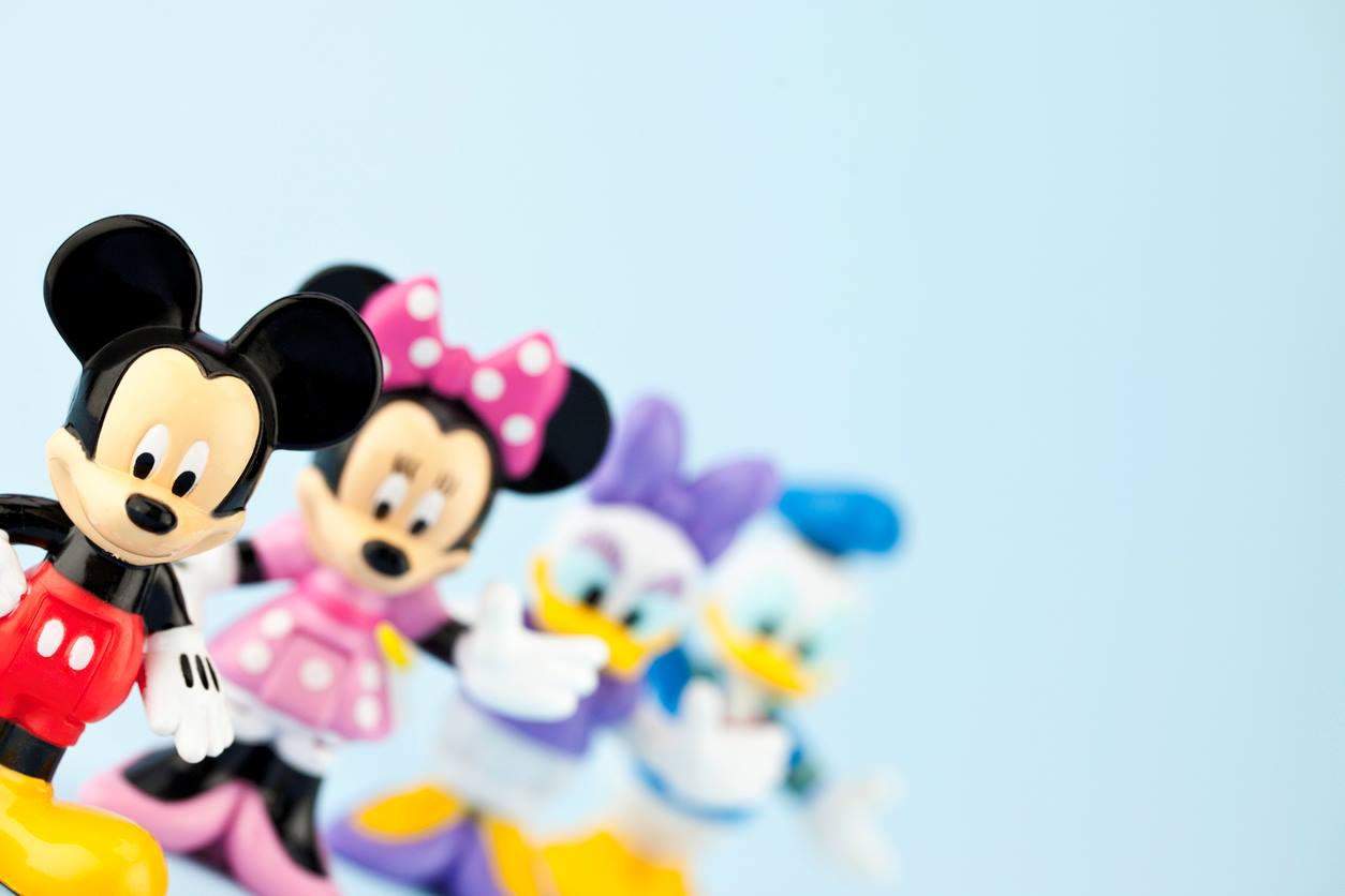 Personagens da Disney em miniaturas, incluindo Mickey Mouse, Minnie Mouse, Margarida e Pato Donald, alinhados em uma fileira. 