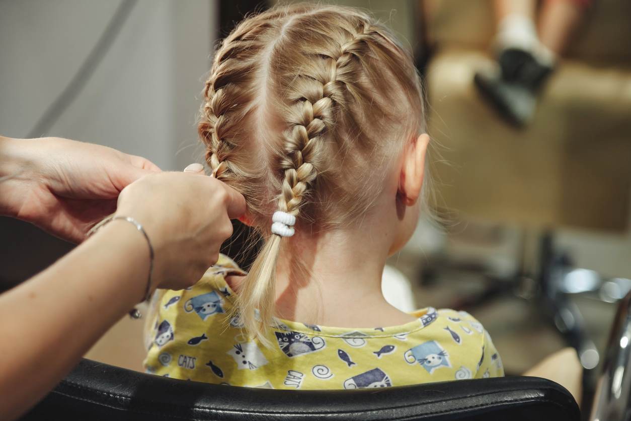 Menina com penteado infantil de tranças duplas.