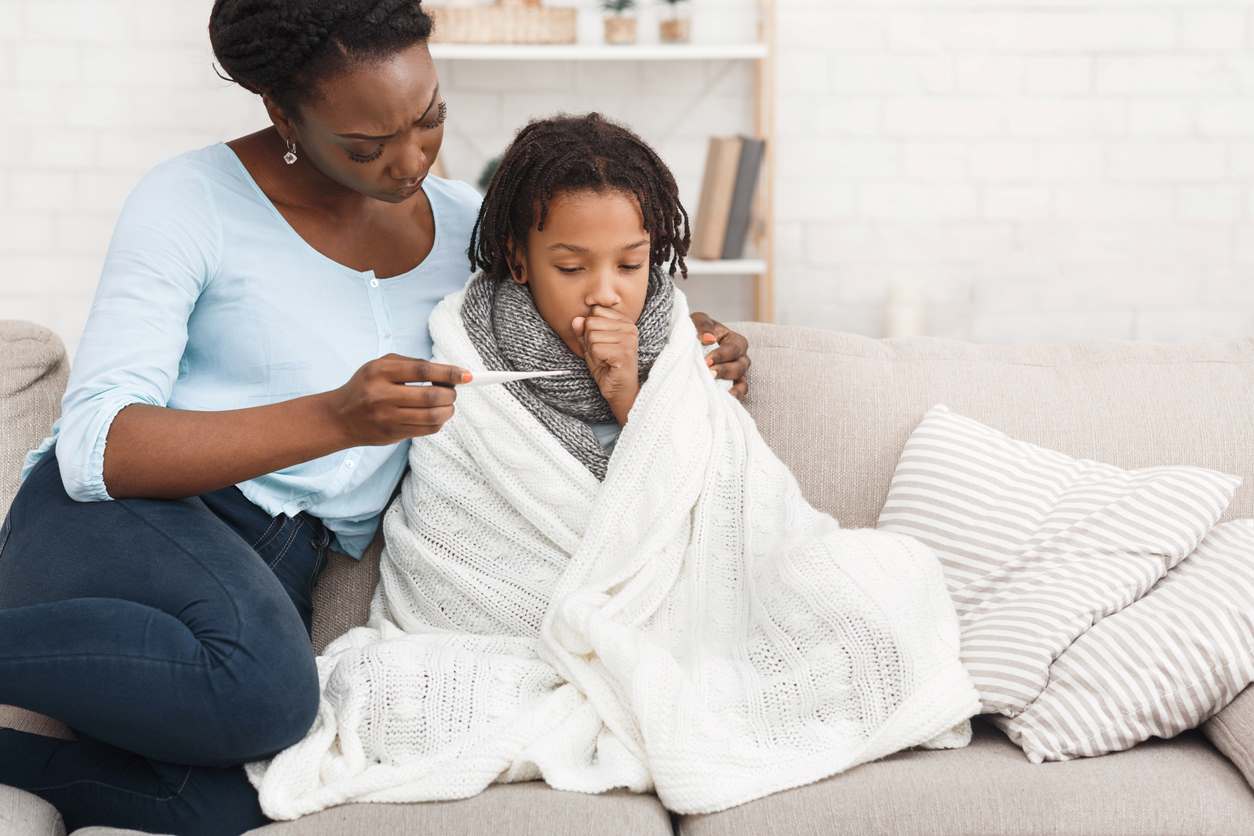 Mãe cuidando do filho com gripe ou resfriado.