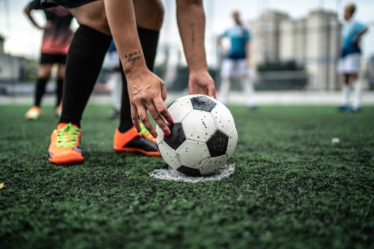 jogador de futebol colocando uma bola no campo antes de cobrar uma falta. 