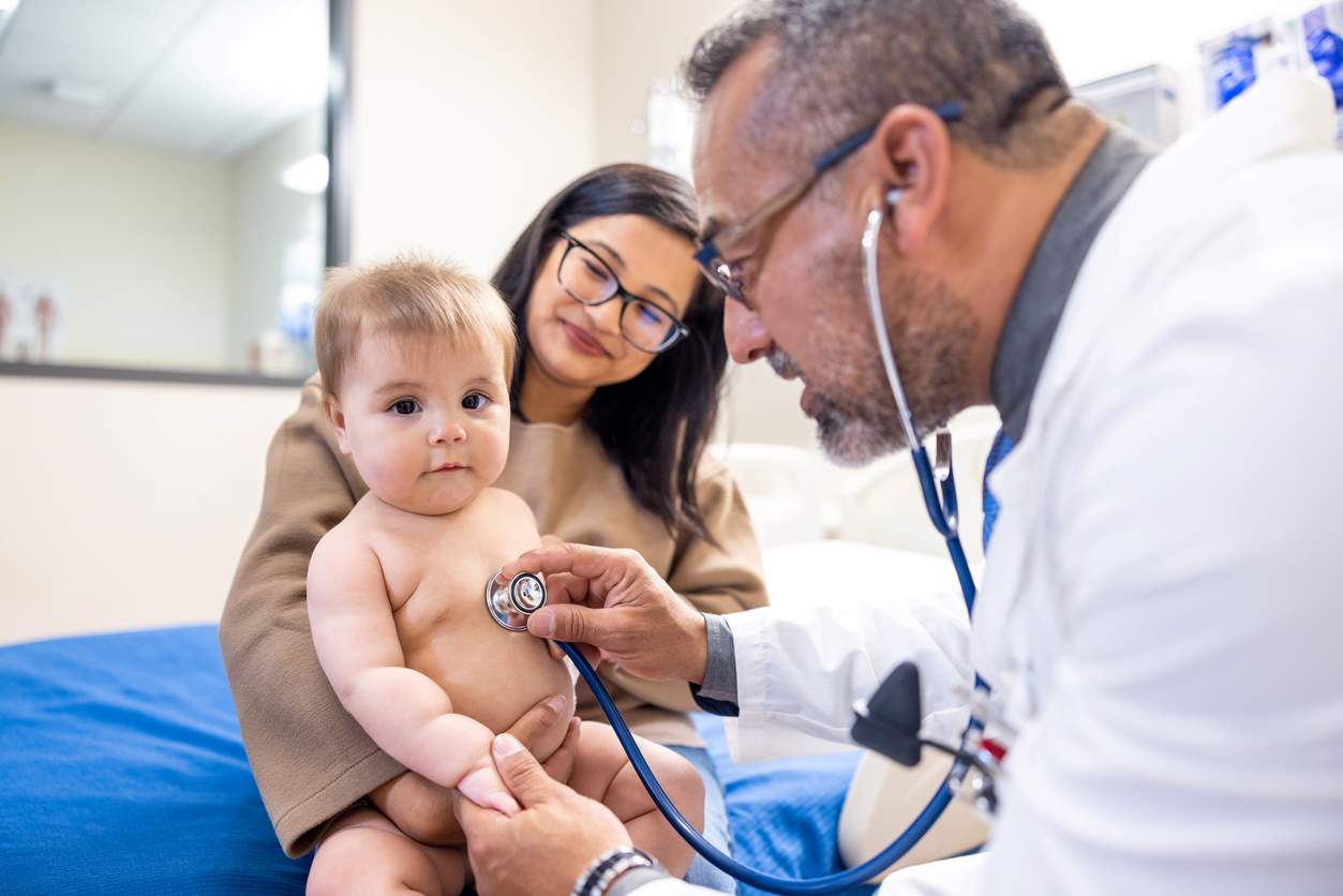 Médico usando estetoscópio para examinar bebê 